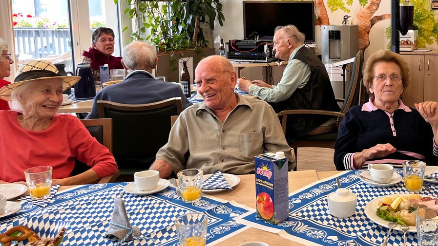 Am Tisch wird viel gelacht und gemeinsam geschlemmt &ndash; die Bewohner*innen der ProCurand Seniorenresidenz B&ouml;lschestra&szlig;e genie&szlig;en das Oktoberfest in vollen Z&uuml;gen!
